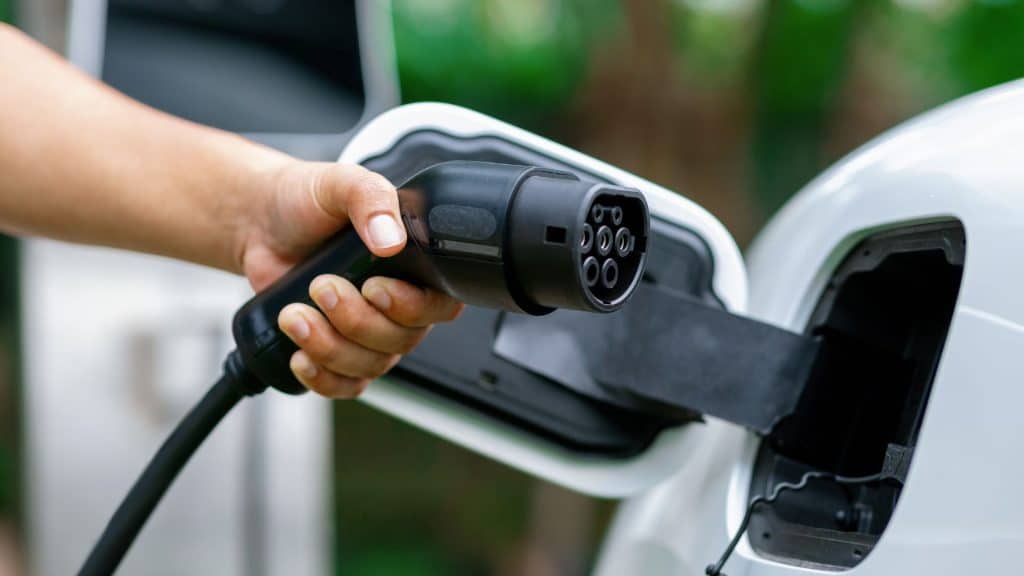 Person charging electric vehicle