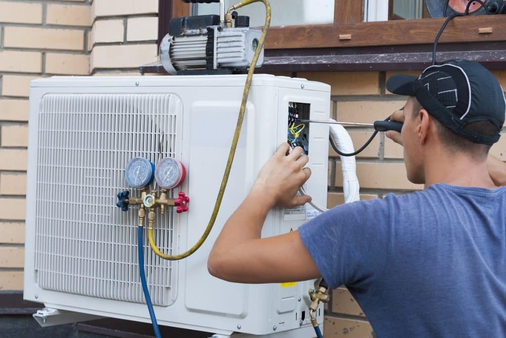 Professional HVAC tech installing an air conditioner
